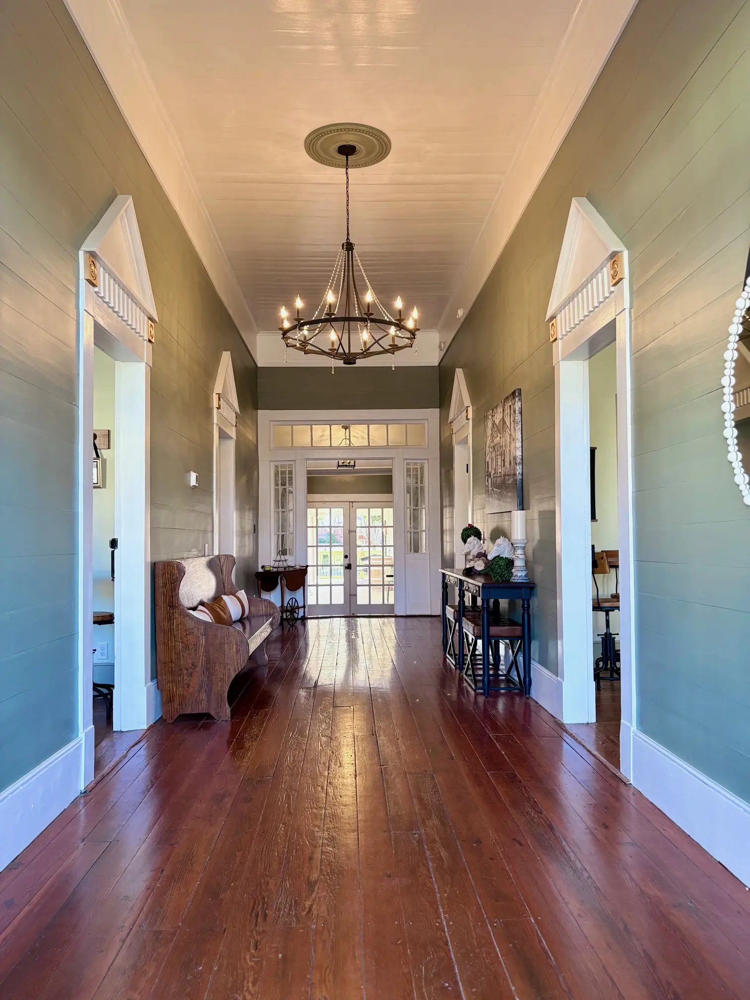 Elegant hallway with hardwood floors and a chandelier.