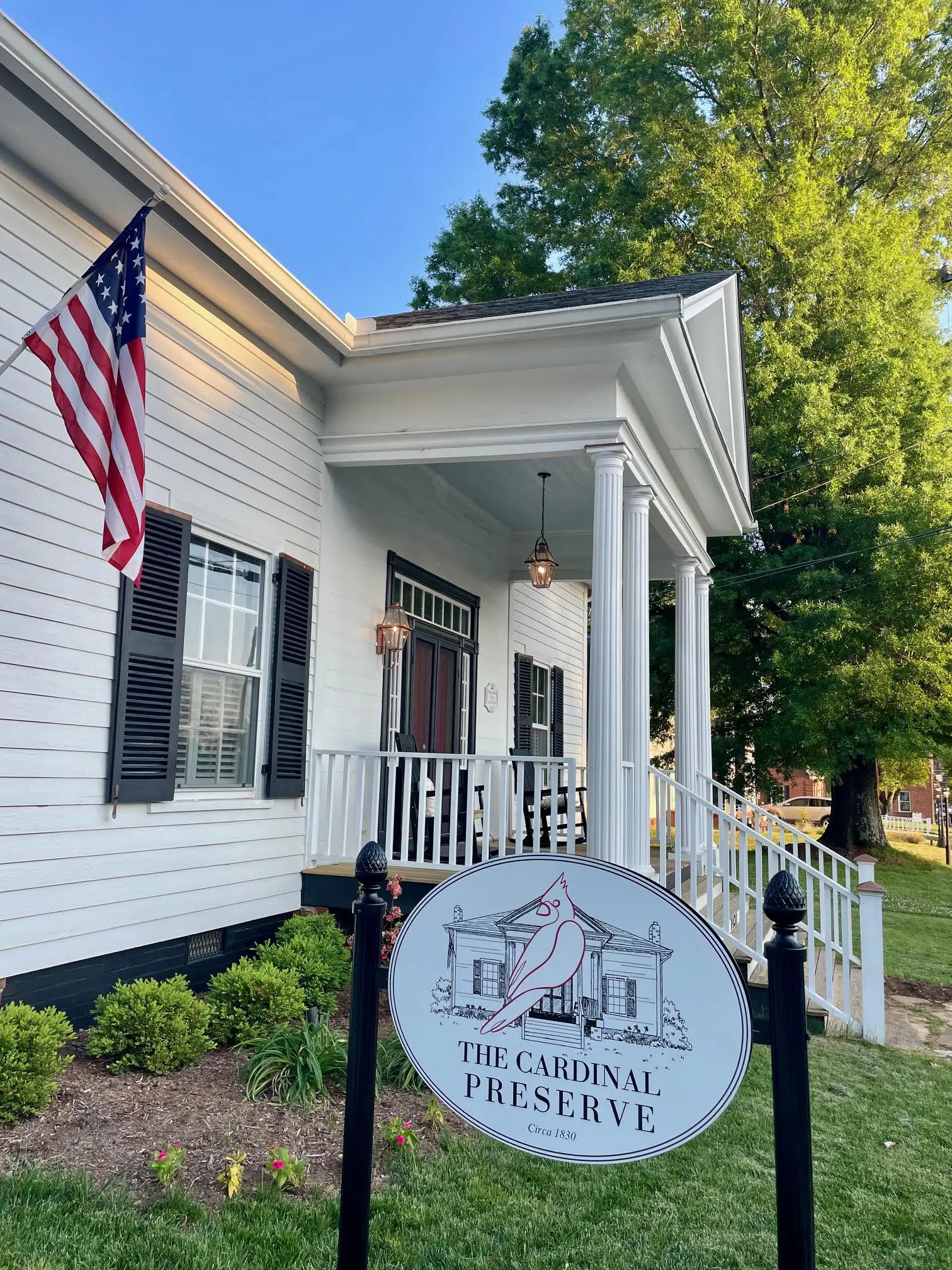 Front porch of The Colonial Preserve with an American flag and white columns.