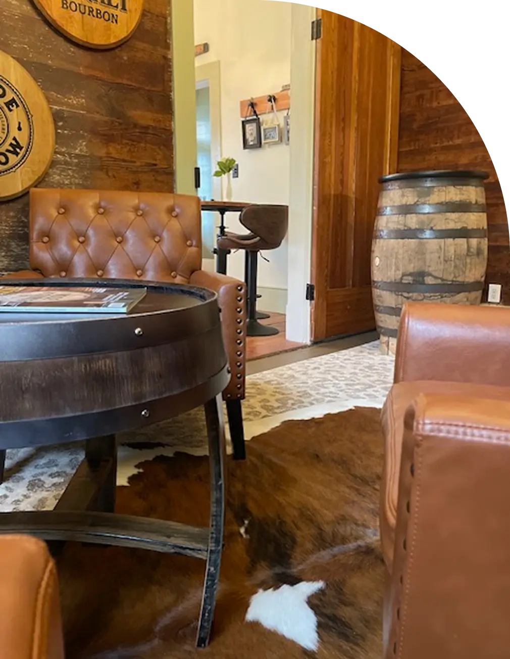 Rustic lounge with leather chairs and barrel.